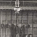 People gathered beneath hanging oil lamp