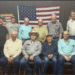 Group of men posing before American flag